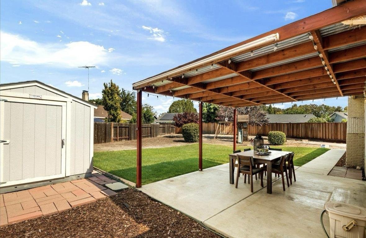 Current patio with wooden pergola structure
